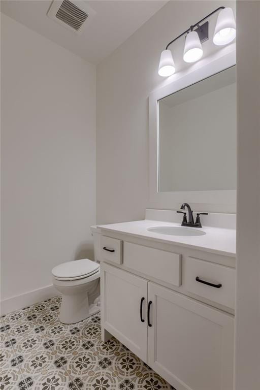 bathroom with tile patterned flooring, vanity, and toilet