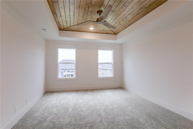 spare room featuring ceiling fan, carpet flooring, a raised ceiling, and wooden ceiling