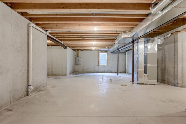 basement featuring heating unit and electric panel