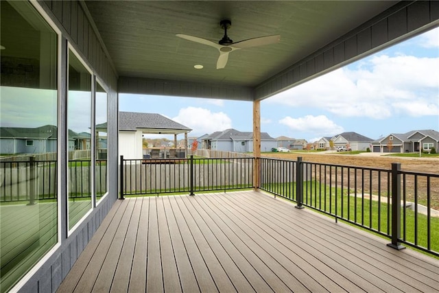 wooden deck with a lawn and ceiling fan