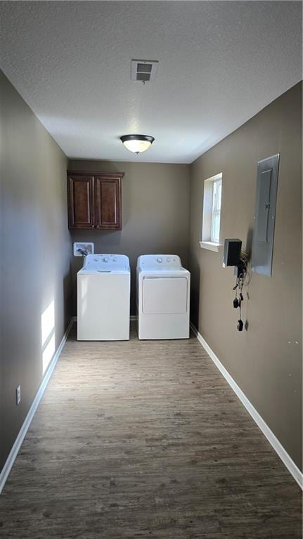 clothes washing area featuring electric panel, cabinets, independent washer and dryer, and dark hardwood / wood-style floors