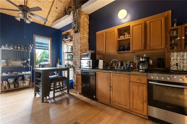 kitchen with stainless steel appliances, vaulted ceiling, ceiling fan, sink, and light hardwood / wood-style flooring