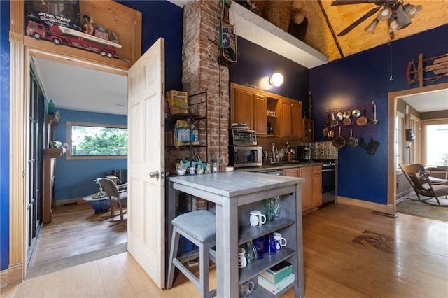 kitchen with ceiling fan, a healthy amount of sunlight, light wood-type flooring, and tasteful backsplash