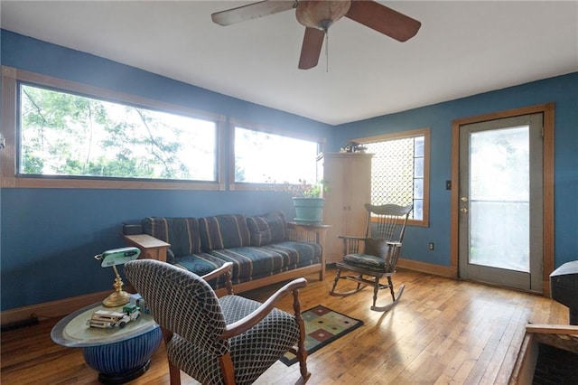 living room featuring light hardwood / wood-style flooring, ceiling fan, and a healthy amount of sunlight