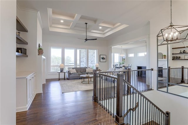 hall with dark wood-style flooring, coffered ceiling, a towering ceiling, an upstairs landing, and beamed ceiling