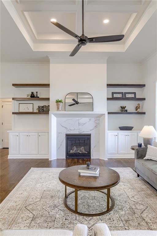 12300 S Hastings St, Olathe, KS 66061 - living area featuring ceiling fan, a premium fireplace, dark wood-style flooring, a tray ceiling, and crown molding