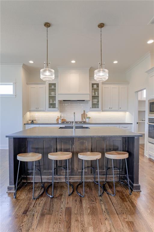 12300 S Hastings St, Olathe, KS 66061 - kitchen with crown molding, stainless steel oven, a large island, white cabinets, and decorative backsplash