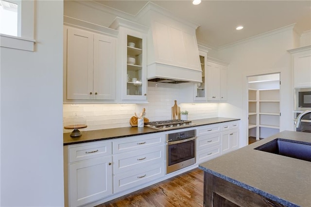 12300 S Hastings St, Olathe, KS 66061 - kitchen featuring appliances with stainless steel finishes, decorative backsplash, dark countertops, white cabinetry, and glass insert cabinets