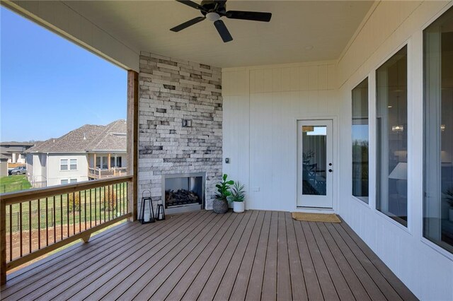 12300 S Hastings St, Olathe, KS 66061 - wooden deck with an outdoor stone fireplace, a ceiling fan, and a residential view