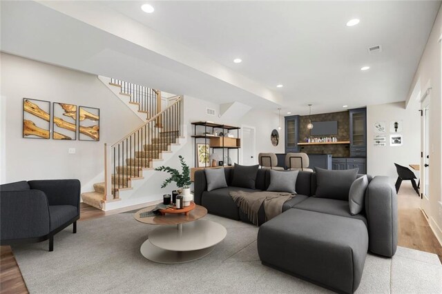 living room with bar area and hardwood / wood-style flooring