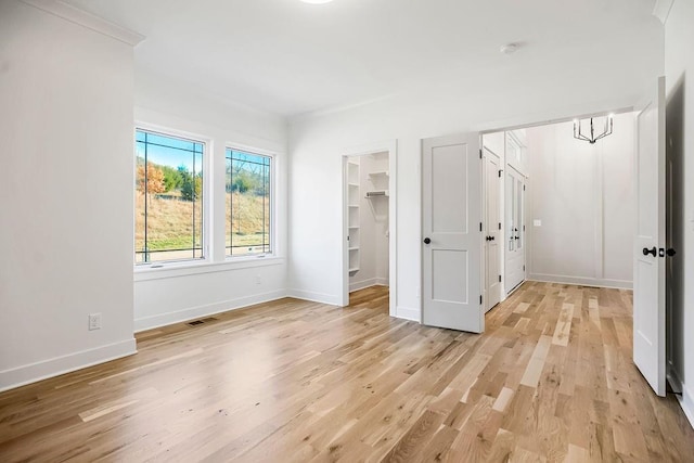 12484 S Barth Rd, Olathe, KS 66061 - unfurnished bedroom with light wood-style flooring and a walk in closet