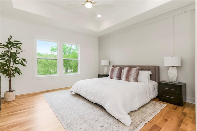 12484 S Barth Rd, Olathe, KS 66061 - bedroom featuring light wood-style flooring, a tray ceiling, recessed lighting, and a ceiling fan