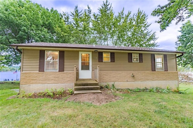 view of front of house with a front lawn and brick siding