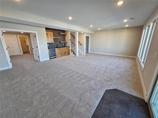 unfurnished living room with beverage cooler and dark carpet