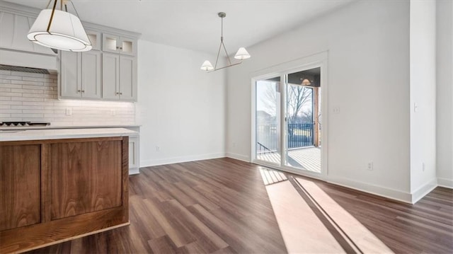 kitchen with decorative backsplash, decorative light fixtures, and dark hardwood / wood-style floors