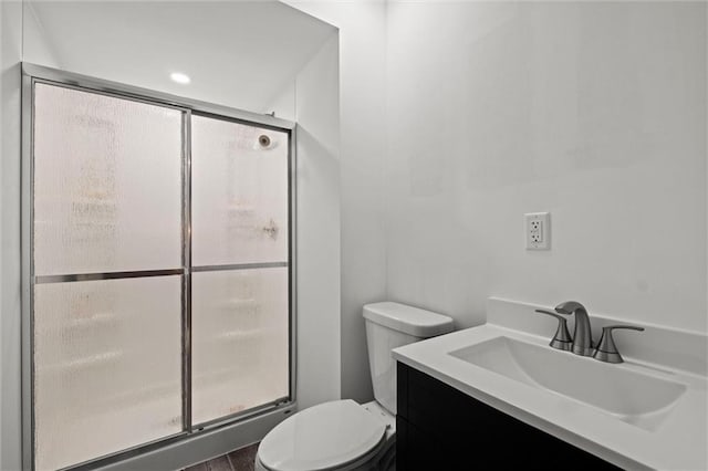 bathroom with walk in shower, vanity, and toilet