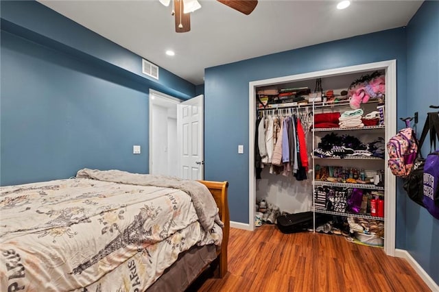 bedroom featuring hardwood / wood-style flooring, ceiling fan, and a closet