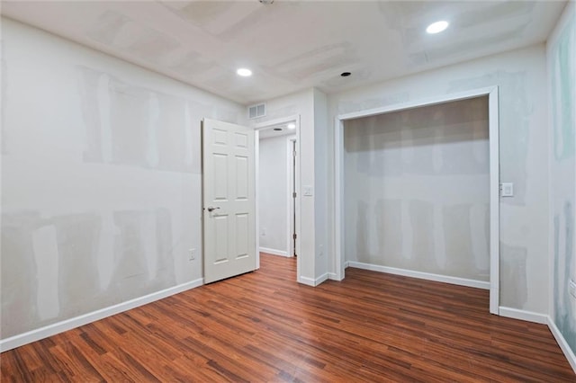 unfurnished bedroom featuring dark wood-type flooring and a closet