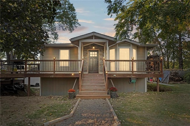 back house at dusk with a deck