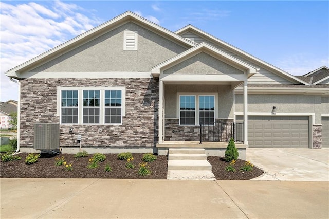 craftsman house featuring a garage, central AC unit, and covered porch