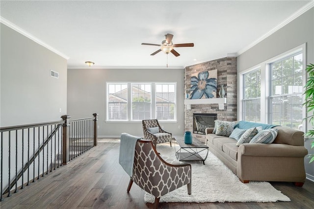 living room featuring a fireplace, dark wood-type flooring, ornamental molding, and plenty of natural light