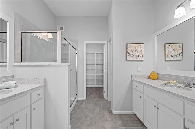 bathroom featuring a shower with door and vanity