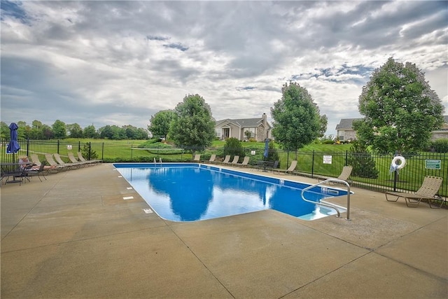 view of swimming pool featuring a yard and a patio