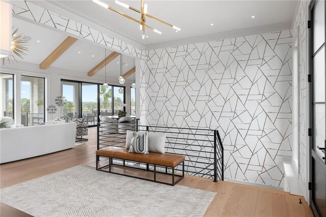 interior space with vaulted ceiling with beams, a notable chandelier, and hardwood / wood-style floors