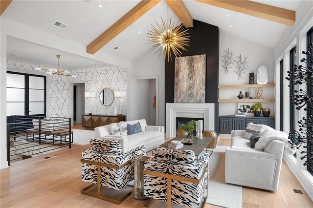 living room featuring vaulted ceiling with beams, light hardwood / wood-style flooring, a fireplace, and a chandelier