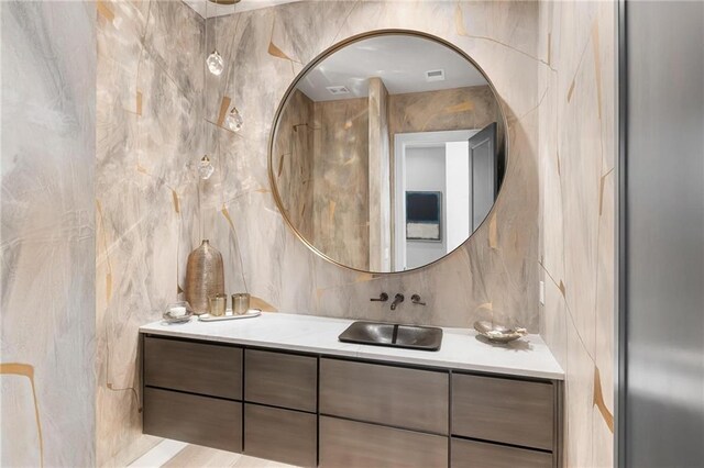 bathroom with backsplash, tile walls, and vanity