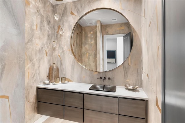 bathroom featuring tasteful backsplash, tile walls, and vanity