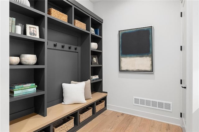 mudroom featuring light wood-type flooring, visible vents, and baseboards