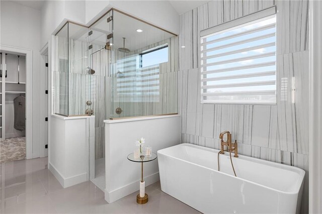 bathroom with tile patterned flooring and separate shower and tub