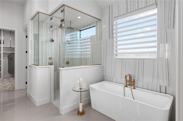 bathroom with a freestanding tub, baseboards, and walk in shower