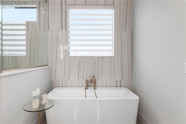 bathroom with a soaking tub and a sink