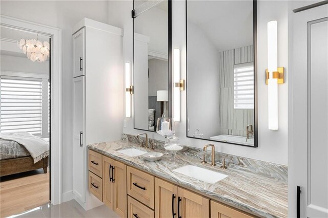 bathroom with dual vanity and hardwood / wood-style floors