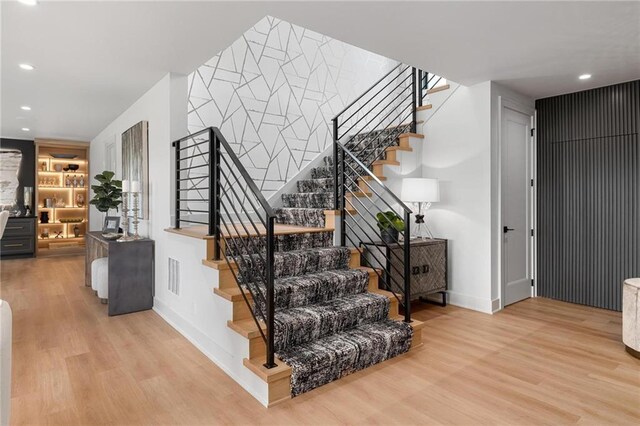 staircase with hardwood / wood-style flooring