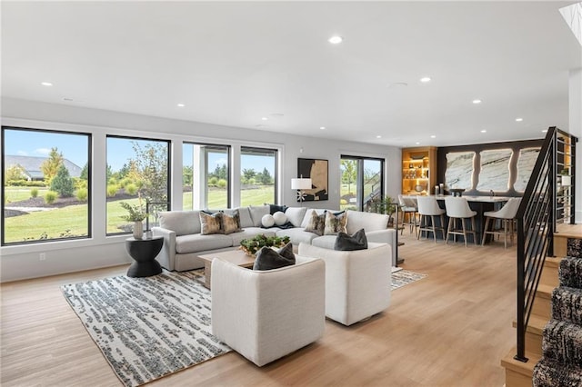 living area featuring light wood finished floors, stairway, and recessed lighting