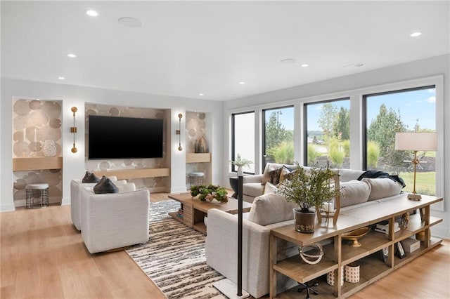 living area featuring light wood-type flooring, baseboards, and recessed lighting