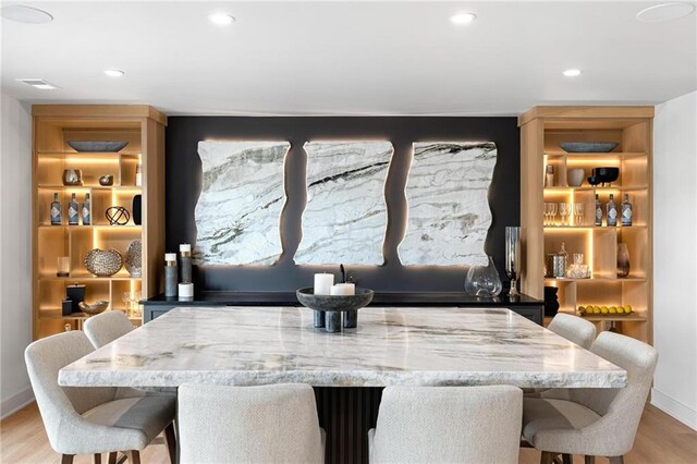 dining space with light wood-type flooring and built in shelves