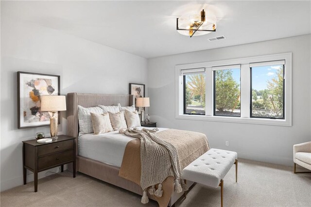 carpeted bedroom featuring multiple windows and an inviting chandelier