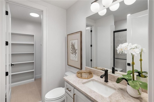 bathroom with toilet, an enclosed shower, and vanity