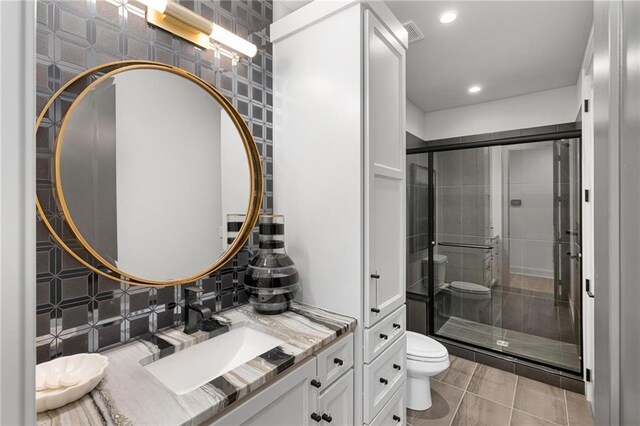 bathroom with toilet, an enclosed shower, backsplash, tile patterned flooring, and vanity