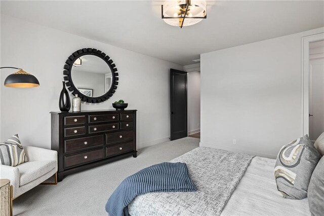 bedroom with light colored carpet and a chandelier