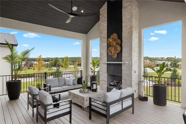 wooden deck with outdoor lounge area and a ceiling fan