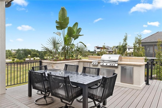 deck with exterior kitchen, area for grilling, and outdoor dining space