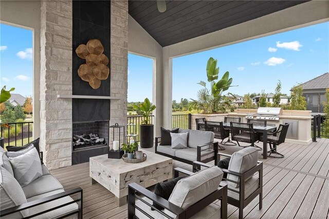 wooden terrace featuring area for grilling and an outdoor living space