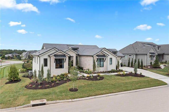 view of front of house with concrete driveway, a tiled roof, a residential view, stucco siding, and a front lawn