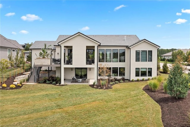 rear view of house featuring a lawn and a patio area