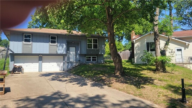 raised ranch with a garage and a front lawn